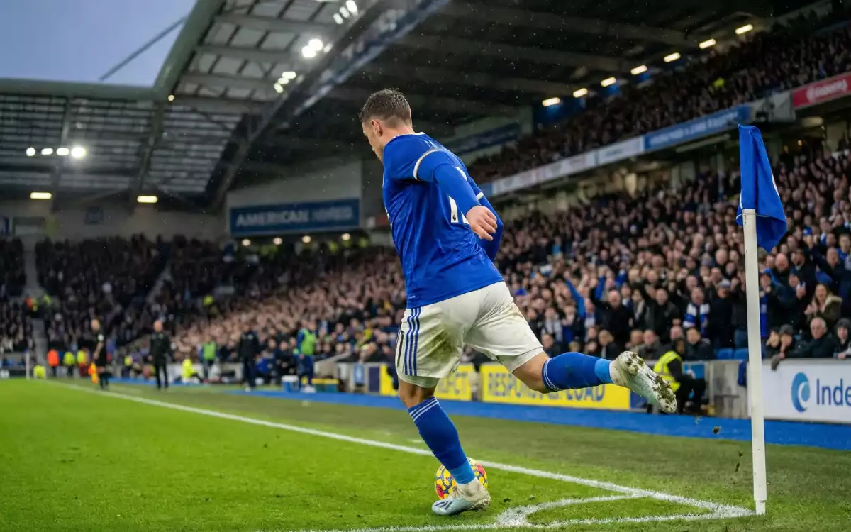 Jugador ejecutando un córner en un partido de fútbol profesional