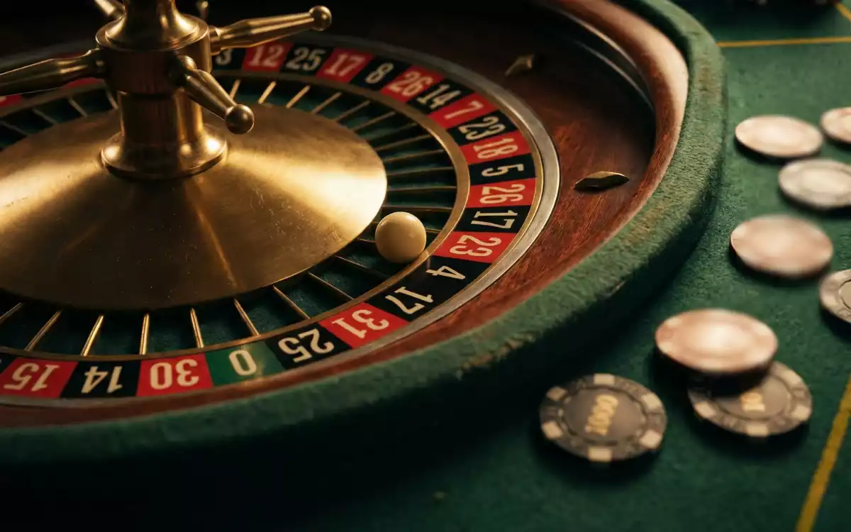 Ruleta de casino con bola en negro rodeada de fichas