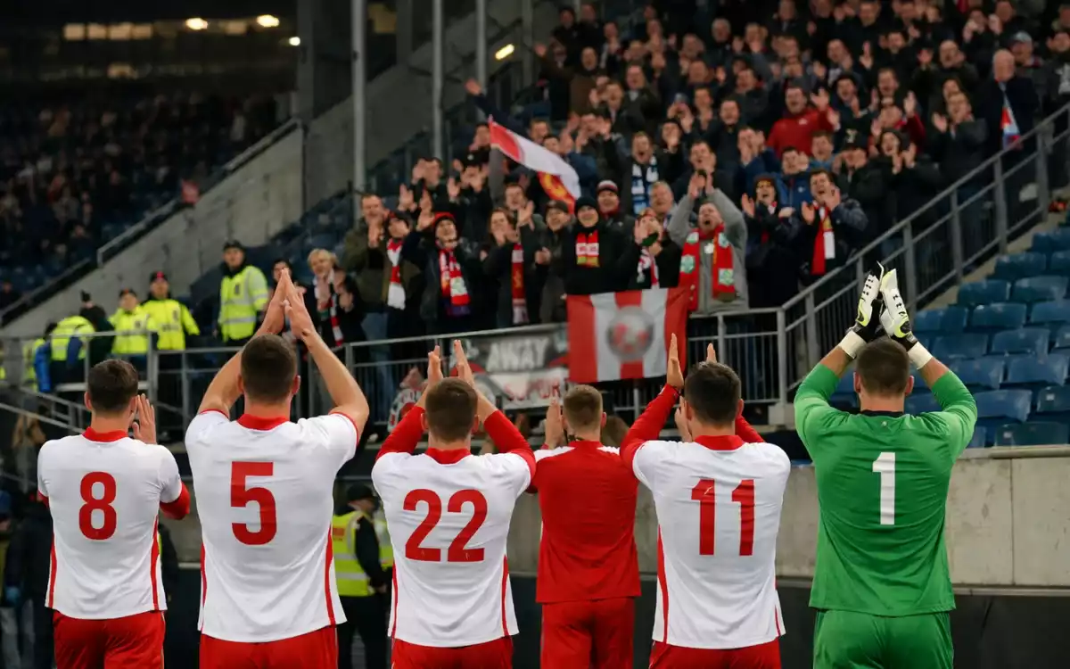 Jugadores de f&uacute;tbol saludando a los aficionados visitantes tras un partido fuera de casa