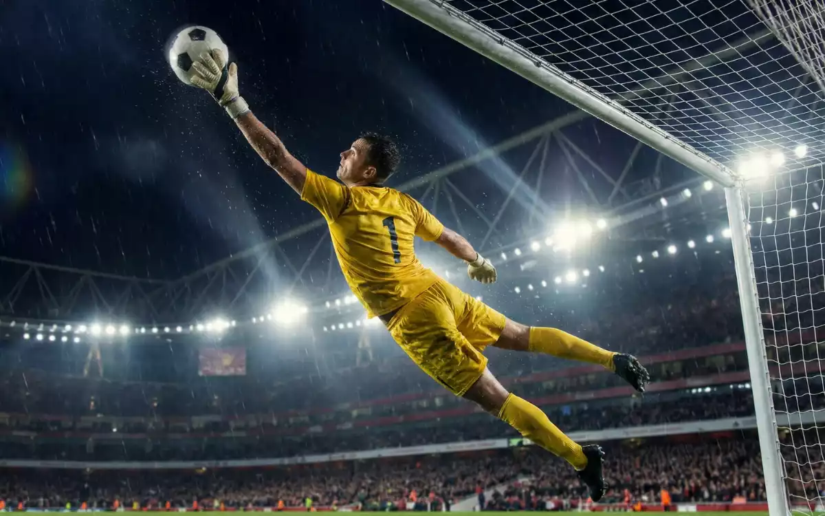 Portero realizando una parada espectacular durante un partido nocturno